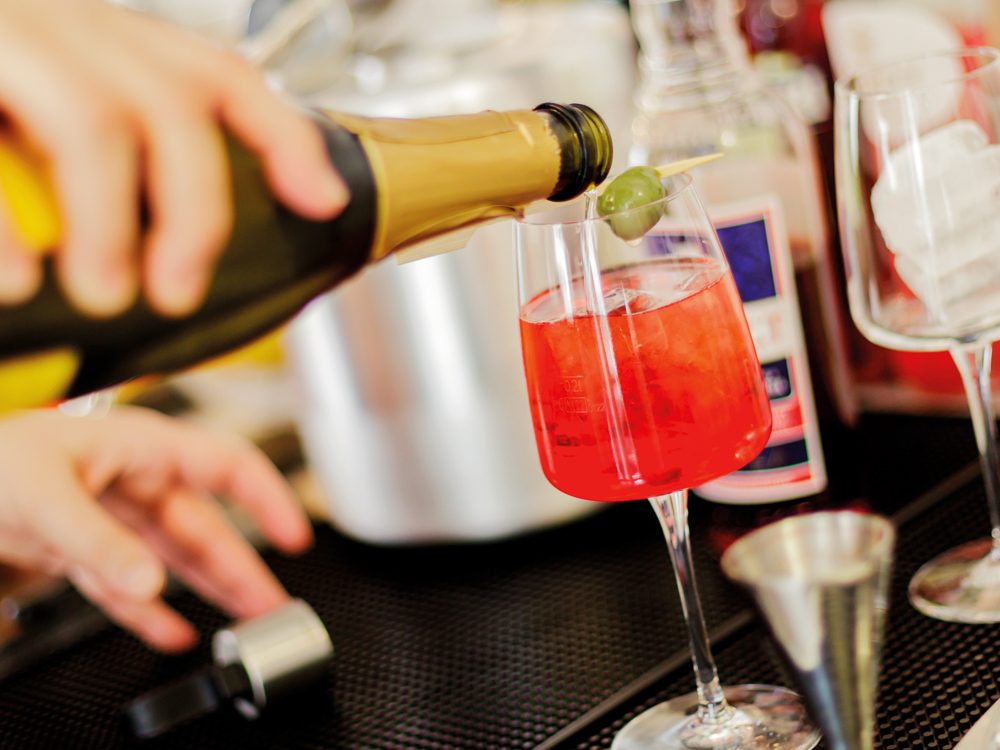 Ein roter Aperitif wird in ein Glas eingeschenkt